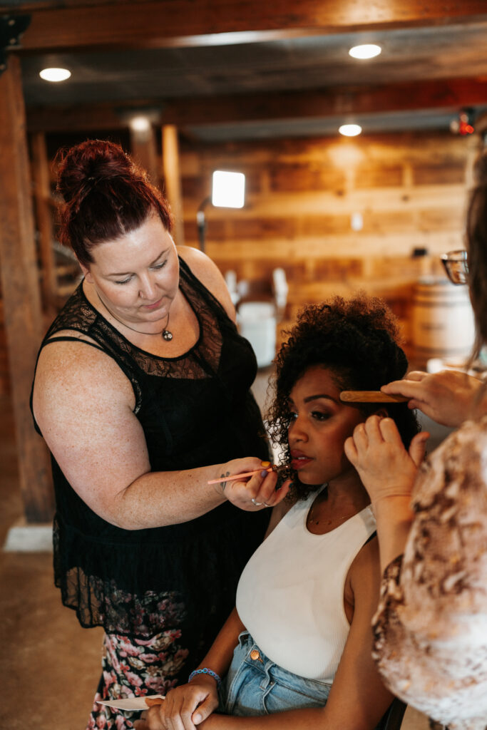 Amanda with Evolution of Beauty putting final makeup touches on the bride